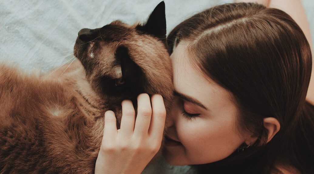 Frau kuschelt mit Ragdoll Katze - positive Effekte von Katzenhaltung